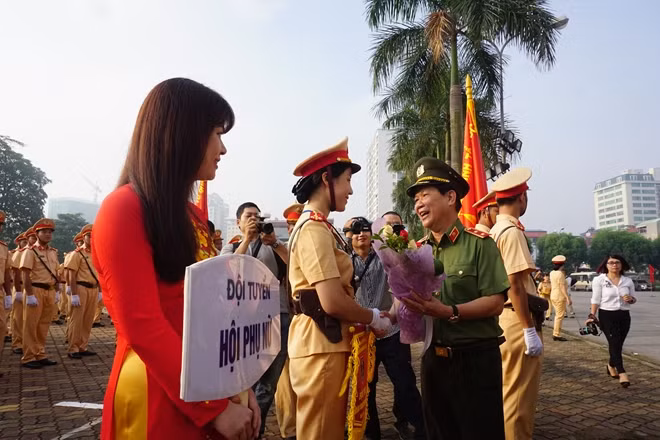 Thứ trưởng Nguyễn Văn Sơn trao hoa và cờ kỷ niệm cho đại diện đội nữ CSGT tham gia cuộc thi