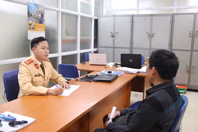 Cảnh sát giao thông mời lái xe vi phạm lên làm việc.