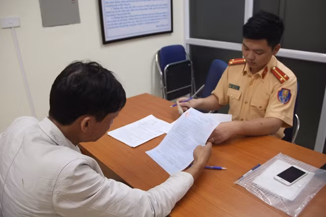 Lái xe ký biên bản vi phạm tại Phòng CSGT Hà Nội ngày 3-4