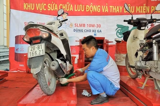 Nhân viên Công ty Honda thay dầu miễn phí cho xe của người tham gia chương trình
