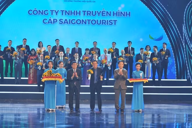 Bộ trưởng Bộ Công Thương - Chủ tịch Hội đồng THQG Trần Tuấn Anh cùng Thứ trưởng Bộ Ngoại Giao Nguyễn Minh Vũ trao biểu trưng và hoa cho các doanh nghiệp có sản phẩm đạt THQG năm 2020