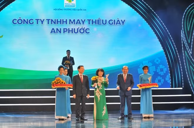 Phó Thủ tướng thường trực Trương Hòa Bình cùng Bộ Trưởng Bộ Thông tin và Truyền thông Nguyễn Mạnh Hùng trao biểu trưng và hoa tặng các doanh nghiệp có sản phẩm đạt THQG năm 2020
