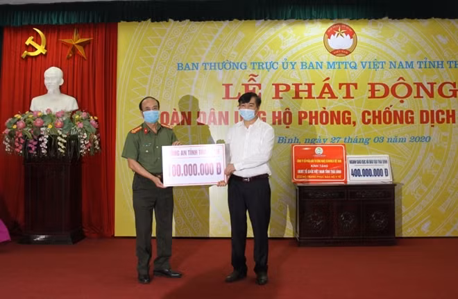 Đại tá Trịnh Đình Thành, Phó Giám đốc Công an tỉnh Thái Bình trao kinh phí ủng hộ công tác phòng, chống dịch COVID-19. Ảnh: Bùi Thành