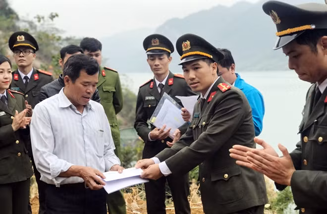 Đại diện Đoàn Thanh niên Cục Đào tạo (Bộ Công an) trao 5 triệu đồng hỗ trợ các hộ dân ở xóm Nhạp.
