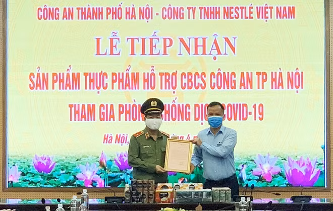 Thiếu tướng Đoàn Ngọc Hùng, Phó Giám đốc Công an TP Hà Nội trao thư cảm ơn của Giám đốc Công an TP Hà Nội tới nhà tài trợ Công ty TNHH Nestlé Việt Nam.