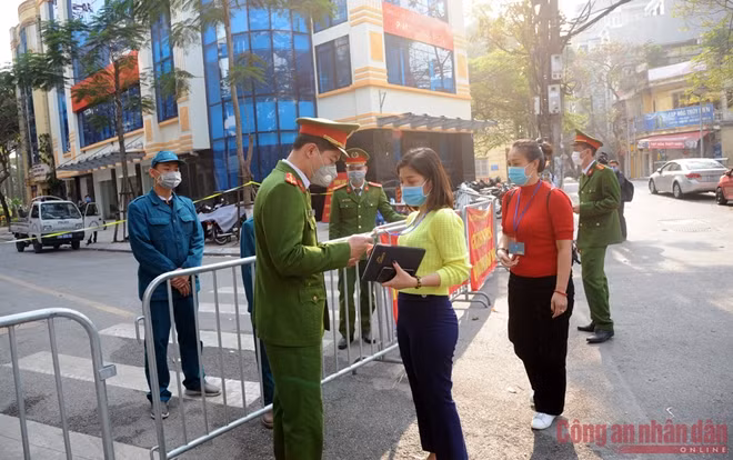 Cán bộ Công an phường trực tại chốt khu vực cách ly kiểm tra thẻ ra vào của những người vào làm nhiệm vụ.