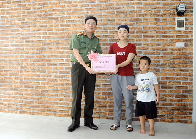 Đại tá Nguyễn Văn Trầm, Phó Giám đốc Công an tỉnh Nam Định động viên và trao quà thăm hỏi Thượng úy Trần Ngọc Yến.
