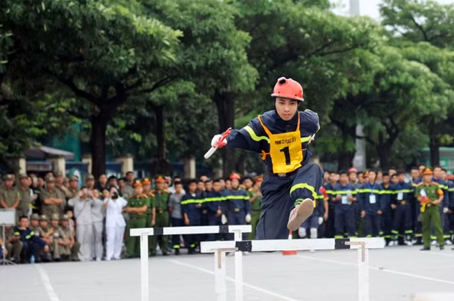 Các vận động viên tranh tài tại môn thi chạy 4x100m vượt chướng ngại vật, cứu nạn, cứu hộ.