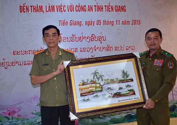 Đồng chí Đại tá Nguyễn Hữu Trí – Giám đốc Công an tỉnh Tiền Giang tặng quà lưu niệm cho đồng chí Thiếu tướng Sỉ Phăn Vông Hương Khăm - Giám đốc Công an tỉnh Chăm pa sắc.