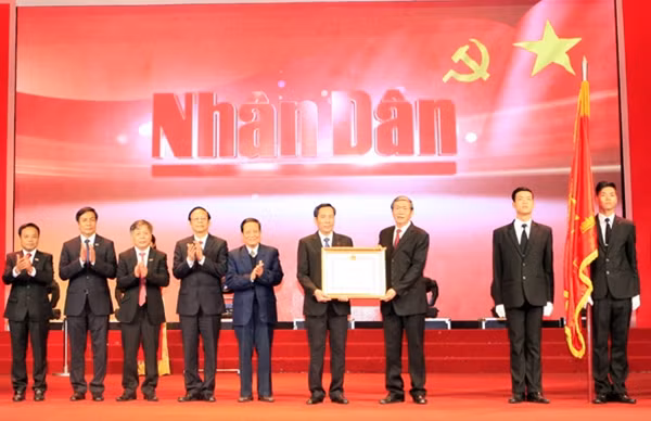 Đồng chí Đinh Thế Huynh, Ủy viên Bộ Chính trị, Thường trực Ban Bí thư trao Huân chương Độc lập hạng Nhất tặng Báo Nhân Dân. Ảnh: TTXVN.
