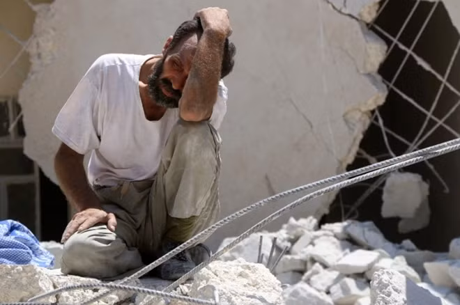 Một người đàn ông Syria khóc thảm thiết và đau khổ vì người thân chết trong trận không kích