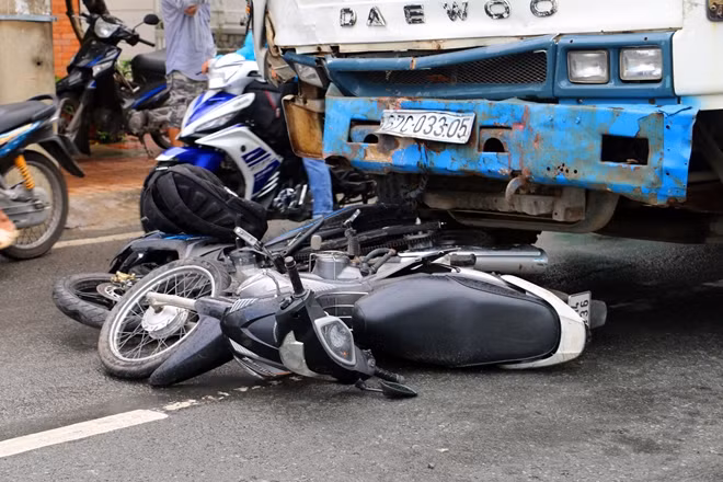 Nhiều xe máy bị cuốn vào gầm xe tải.