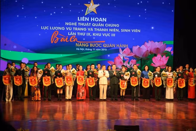 Thượng tướng Nguyễn Trọng Nghĩa, Phó Chủ nhiệm Tổng cục Chính trị QĐND, Thiếu tướng Đào Gia Bảo, Cục trưởng Cục Công tác đảng và Công tác chính trị, Bộ Công an tặng cờ lưu niệm cho các đoàn tham gia Liên hoan