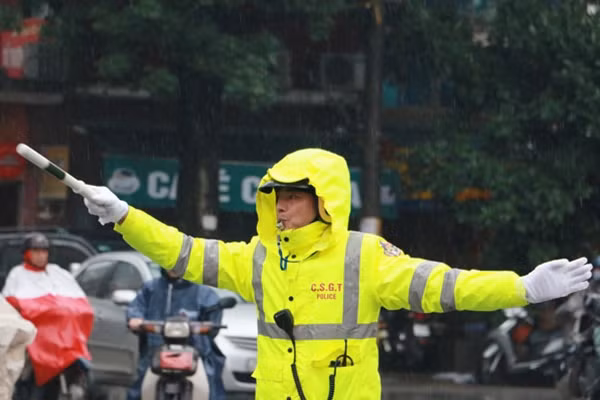 Lực lượng CSGT có mặt tại các ngã tư để làm nhiệm vụ phân làn đường, hướng dẫn người dân đi lại một cách thuận lợi trong tiết trời giá lạnh kèm theo mưa.