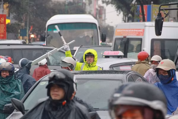 Thời tiết lạnh giá, kèm theo mưa khiến cho việc điều tiết giao thông càng trở nên khó khăn hơn.
