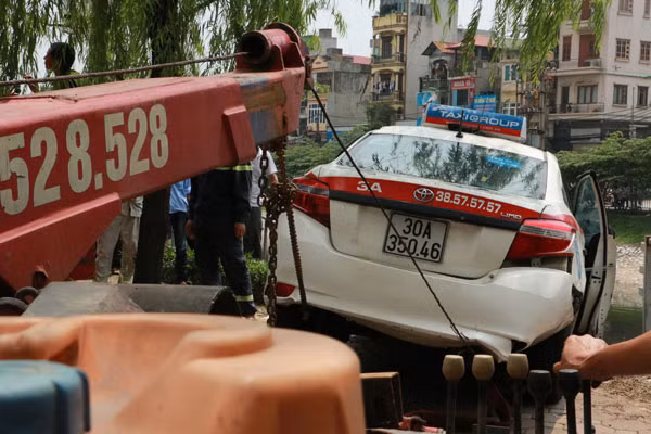 Lực lượng cứu hộ đang kéo chiếc xe lên bờ.