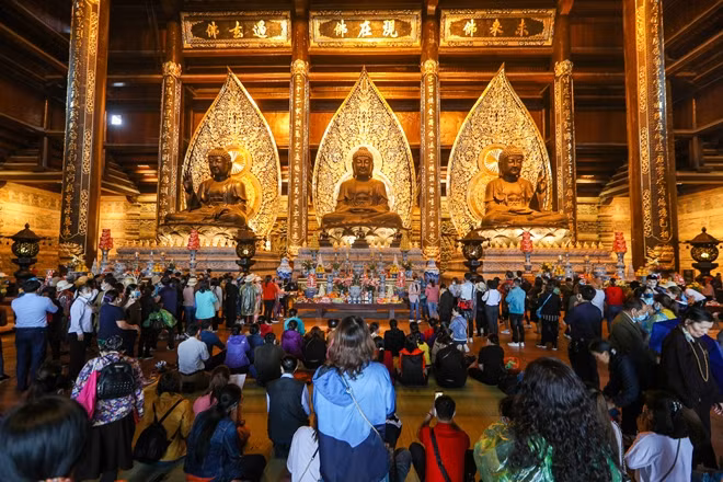 Bên trong điện Tam bảo. Mặc dù đông người nhưng ban quản lý khu du lịch và nhà chùa đã bố trí tình nguyện viên, nhân viên nhắc nhở du khách việc đeo khẩu trang, thường xuyên sát khuẩn tay nếu có điều kiện.