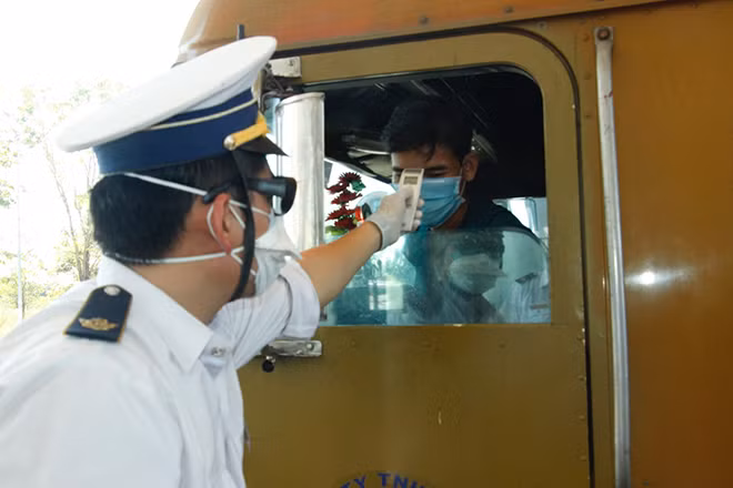 Lực lượng chức năng Cửa khẩu quốc tế Hoa Lư, huyện Lộc Ninh, tỉnh Bình Phước, giáp biên giới Campuchia đo thân nhiệt người, phương tiện nhập cảnh từ Campuchia vào Việt Nam.