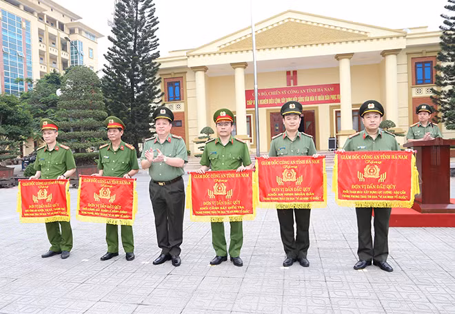 Giám đốc Công an tỉnh Hà Nam Nguyễn Quốc Hùng trao cờ cho các tập thể dẫn đầu phong trào thi đua.