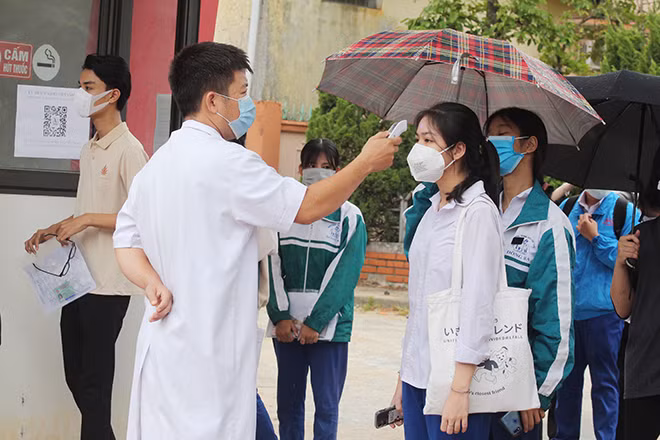 Thí sinh đến làm thủ tục tại Điểm thi Trường THPT Chuyên Lê Quý Đôn (Quảng Trị) được đo thân nhiệt đảm bảo phòng chống COVID-19.