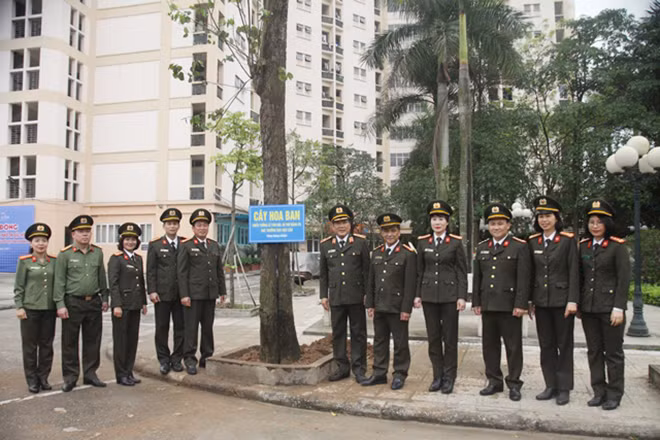 Đồng chí Cục trưởng Thiếu tướng Lê Văn Hải và các CBCS chụp ảnh lưu niệm bên gốc cây bưởi diễn vừa mới trồng.