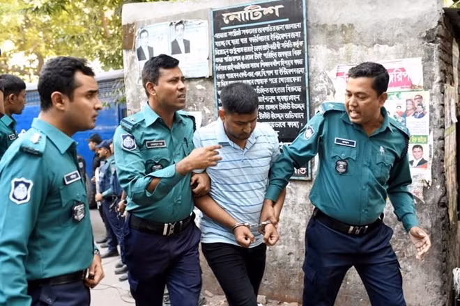 Cảnh sát Bangladesh áp giải một trong 8 kẻ bị buộc tôi thực hiện vụ tấn công đẫm máu năm 2016 tới tòa án tại thủ đô Dhaka hôm 27-11. (Ảnh: Reuters)