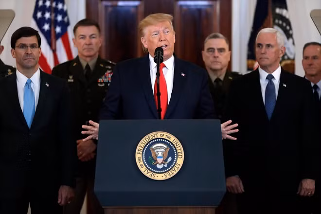 Ông Trump phát biểu tại Nhà Trắng hôm 8-1, phía sau là các quan chức cấp cao trong chính quyền, bao gồm Bộ trưởng Quốc phòng Mark Esper, Phó tổng thống Mike Pence (Ảnh: AP)
