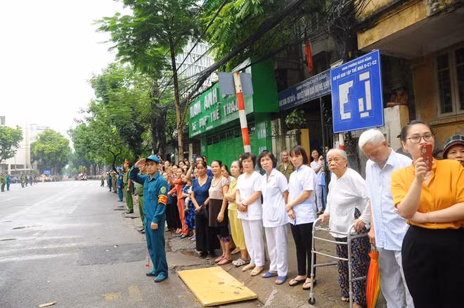 Những người dân hướng ánh nhìn về phía linh xa chở linh cữu Chủ tịch nước rời Nhà tang lễ quốc gia.