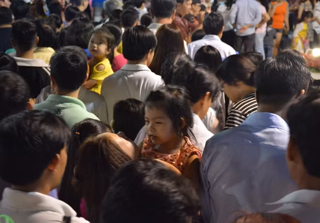 Một em bé bị kẹt giữa đám đông