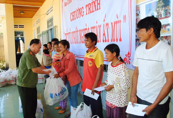 Đại tá Trần Kim Thẩm, Phó Tổng biên tập Báo CAND trao quà Tết cho đồng bào nghèo tại xã Sa Loong, huyện Ngọc Hồi.
