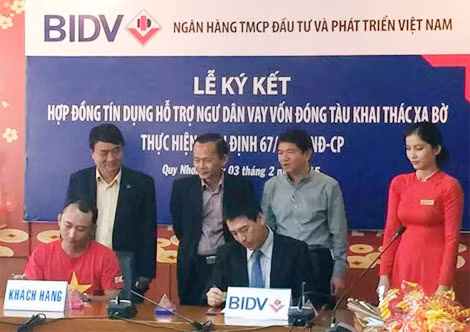 Đại diện BIDV ký hợp đồng cho ngư dân Bình Định vay vốn đóng tàu.