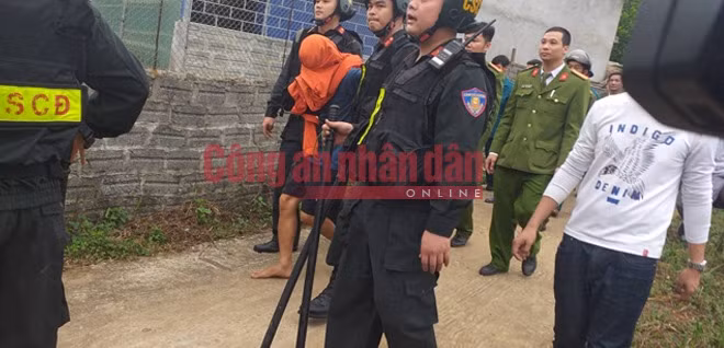 Hung thủ Hoàng Văn Chín (đầu bị trùm áo màu cam) đã bị bắt giữ lúc 10 giờ sáng 26-12.