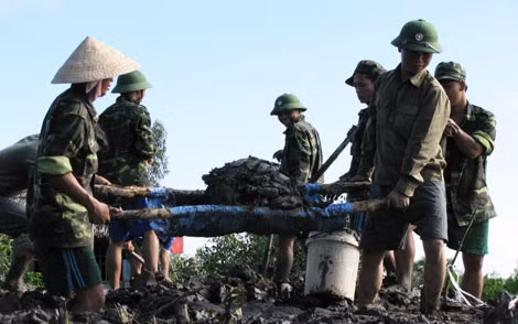 Cán bộ, chiến sỹ Đồn Biên phòng Sông Đốc (Cà Mau) giúp địa phương làm đường giao thông nông thôn.