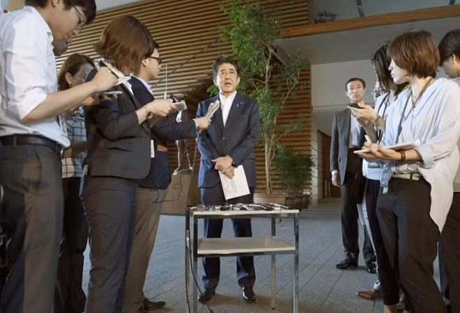 Thủ tướng Nhật Bản Shinzo Abe trao đổi với phóng viên sau cuộc điện đàm. Ảnh: Reuters