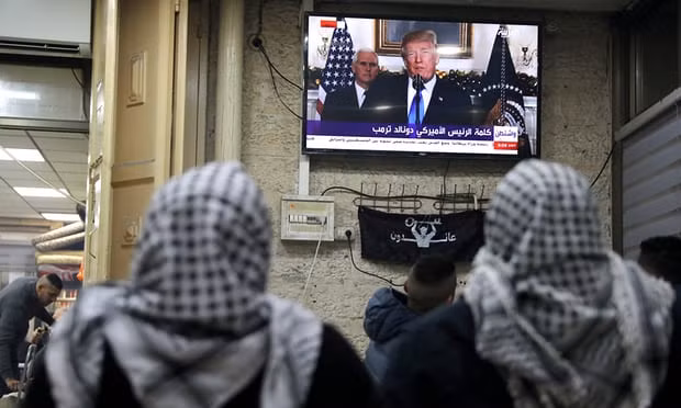 Người dân Palestine theo dõi bài phát biểu của Tổng thống Mỹ Donald Trump qua truyền hình hôm 6-12. Ảnh: Reuters