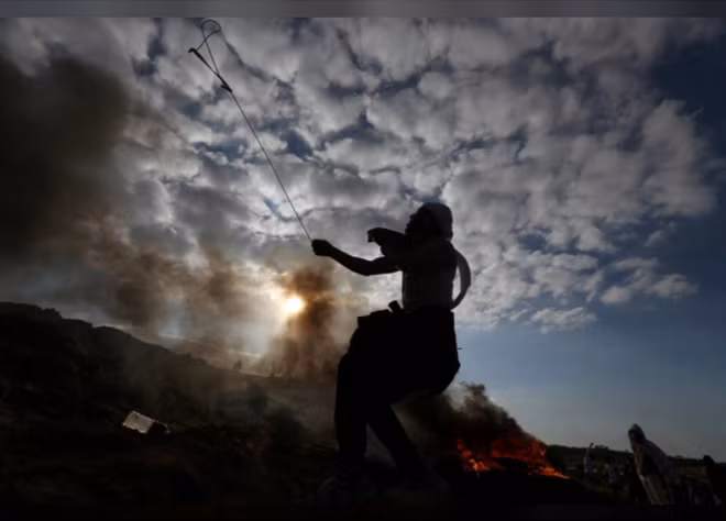 Một người biểu tình Palestine đang sử dụng dây dài để quăng đá về phía lực lượng cảnh sát Israel. Cuộc biểu tình xảy ra tại khu vực ở Dải Gaza. AFP dẫn tin từ Bộ Y tế Palestine cho biết, một người Palestine đã tử vong sau khi bị trúng đạn của lực lượng an ninh Israel khi tham gia biểu tình tại đây.