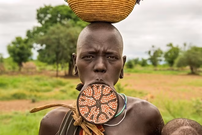 Quan niệm khác lạ về cái đẹp Người Surma ở Ethiopia nổi tiếng với phong tục lồng đĩa vào môi. Đây được coi là biểu tượng của vẻ đẹp và đẳng cấp xã hội cho phụ nữ trong bộ tộc. Người Surma có hai tộc là Suri và Mursi, sinh sống rải rác dọc sông Omo miền tây nam Ethiopia. Ảnh: Louisa Seton