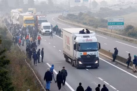 Một nhóm người di cư tụ tập trên con đường dẫn tới cảng Calais.