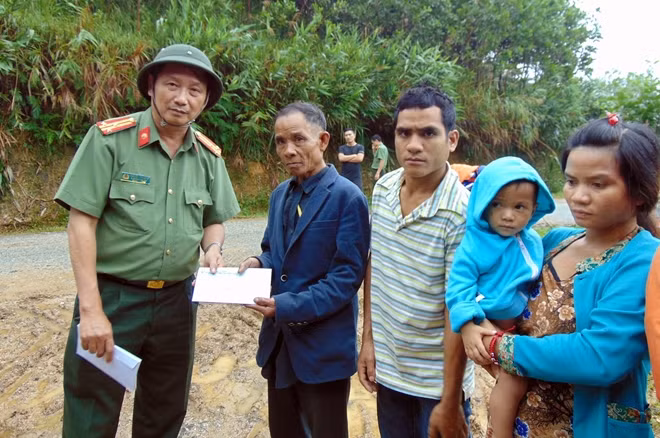 Thượng tá Nguyễn Văn Long, Trưởng Văn phòng thường trú miền Trung Báo CAND, trao quà cho thân nhân các nạn nhân sạt lở núi ở Trà Vân, Nam Trà My.