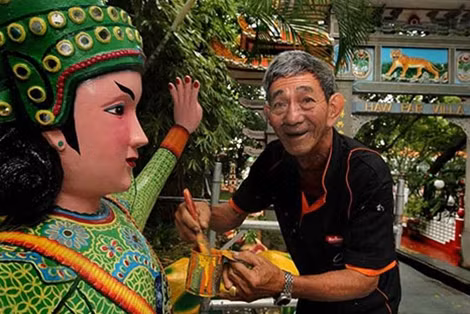 Ông Teo Veoh Seng đang sơn một bức tượng.