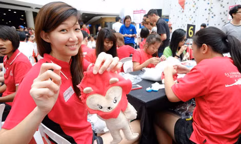 Charmaine Soh, tuyển thủ ĐT bóng lưới Singapore (bên trái) đang khâu một chú Nila.