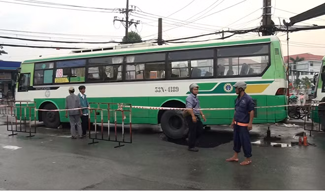 Bánh xe sau của xe buýt bị sụp xuống hố.