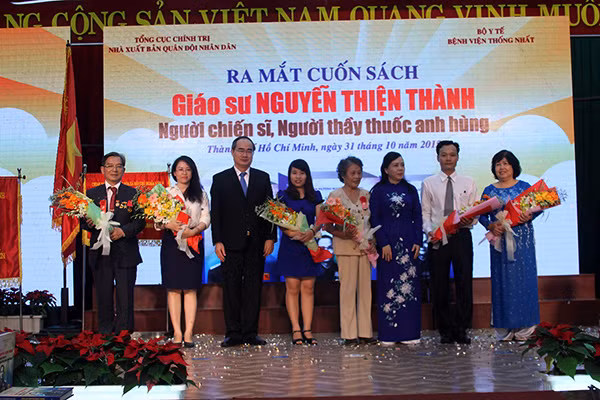 Giáo sư Nguyễn Thiện Nhân tặng hoa nhóm tác giả và nhân vật tham gia giao lưu.
