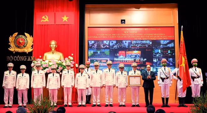 Chủ tịch nước Nguyễn Xuân Phúc gắn Huân chương lên Cờ truyền thống và trao Bằng Huân chương Bảo vệ Tổ quốc hạng Nhất tặng lực lượng ANND.