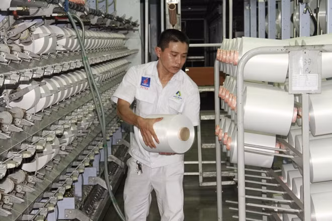Công nhân kỹ thuật xưởng Filament - NMXS Đình Vũ đứng máy sản xuất sợi DTY.