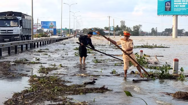 CSGT tỉnh Quảng Nam dọn dẹp cây cối, rác để thông xe tuyến quốc lộ 1A sau khi nước lũ vừa cạn.