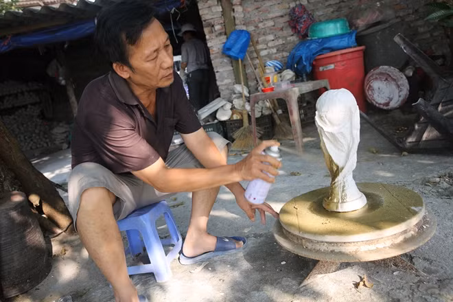 Ông Vương Hồng Nhật tự tay phủ nhũ vàng từng chiếc cúp.