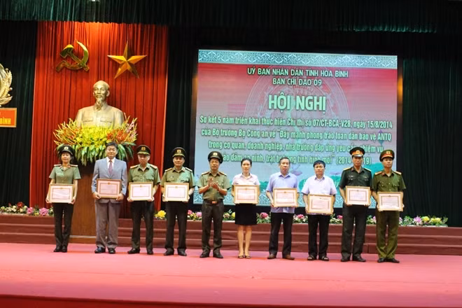 Đồng chí Phạm Hồng Tuyến Giám đốc Công an tỉnh Hòa Bình trao giấy khen cho 9 tập thể tiêu biểu.