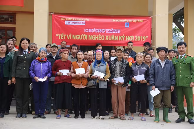 Thiếu tá Cao Thị Hồng, Phó trưởng Ban Kinh tế - Pháp luật, Báo CAND cùng đại diện Công an huyện Văn Yên trao quà Tết tới đồng bào nghèo xã Ngòi A.