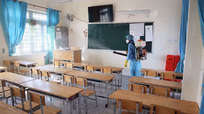 Cán bộ Y tế tỉnh Bình Phước phun hóa chất khử khuẩn tại Trường Tiểu học Tiến Thành, phường Tiến Thành, TP Đồng Xoài, tỉnh Bình Phước.